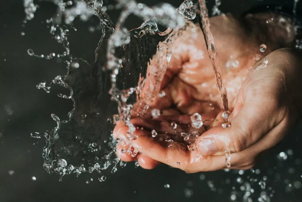 Hände fangen Wasser auf, um Wasser zu sparen