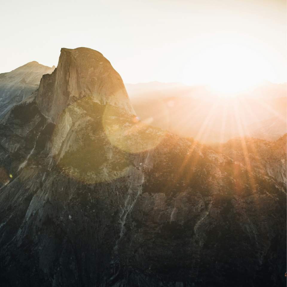 Vision und Markenwerte von we:care²: Bild einer Berglandschaft mit einer strahlenden Sonne im oberen rechten Bildrand, der einen Blick in die positive Zukunft symbolisieren soll.