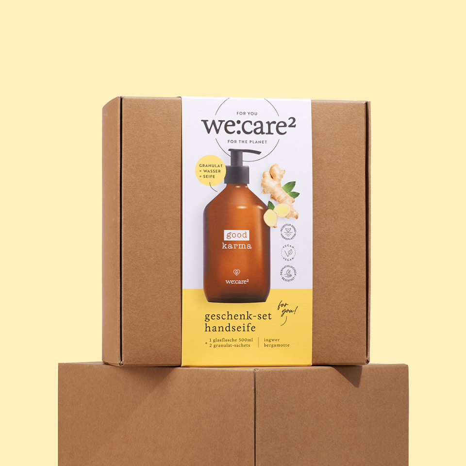 Das Good Karma Geschenkset Ingwer Bergamotte in der Verpackung vor gelbem Hintergrund